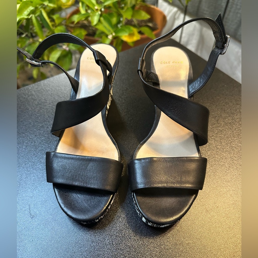 Cole Haan black leather wedge sandals with black and white detail on the heel.